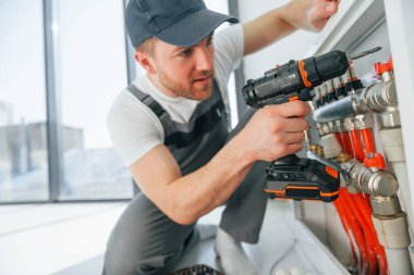 Boru döşeniyor. Tamirci modern odada kapalı alanda çalışıyor..