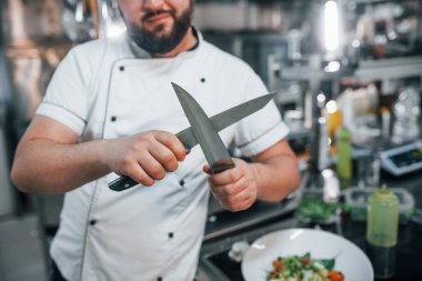 Keskin bıçaklarla. Profesyonel aşçı mutfakta yemek hazırlıyor..