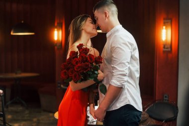 Erkekler çiçek verir. Romantik çift restoranda yemek yiyor..