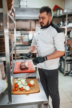 Adam salata yapıyor. Profesyonel aşçı mutfakta yemek hazırlıyor..