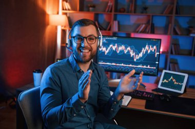 Oturup kameraya bakıyorum. Hisse senedi tüccarı kapalı alanda bilgisayar başında çalışıyor. Değişim ve para kavramı.