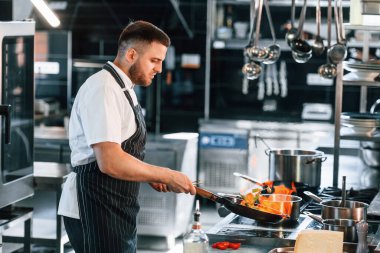 Kızartma tavasında alevler. Şef mutfakta yemek hazırlıyor..