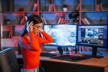 Kulaklıkla. Genç ve güzel oyun flaması bilgisayarla birlikte içeride..