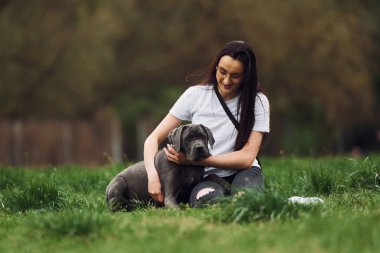 Yerde oturuyordum. Genç esmer kız köpeğiyle dışarıda yürüyüş yapıyor..