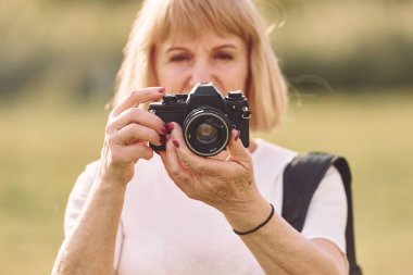Kamerayı kullanarak. Fotoğrafları hazırlıyorum. Sunny Day 'de son sınıf öğrencisi dışarıda güzel bir hafta sonu geçiriyor..