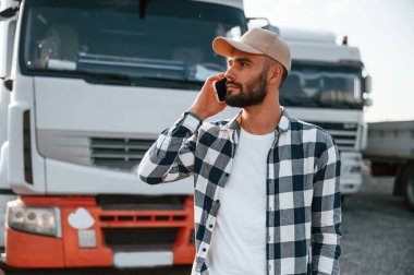 Telefonla konuşuyorum. Genç kamyon şoförü gündüz vakti aracıyla geliyor..