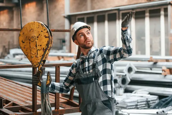 stock image Communicate with crane operator. Factory male worker in uniform is indoors.