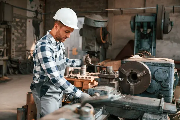 Yan görüş. Makineyi çalıştırıyorum. Üniformalı fabrika çalışanı içeride..