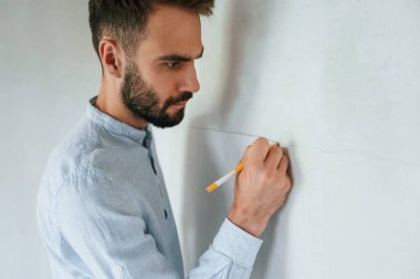 Duvara kalem kalem çiziyorum. Adam dairede tamirat yapıyor..