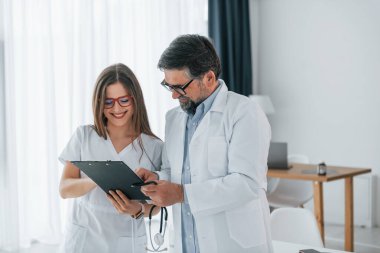 Bilgi okunuyor. Ofiste beyaz önlüklü profesyonel tıp çalışanları var..