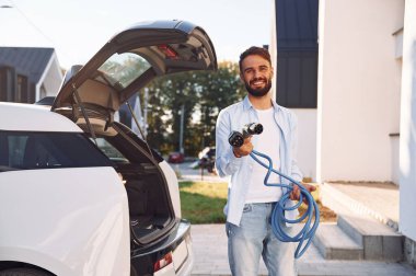 Sarı kabloyu tutuyorum. Genç şık adam, gündüz vakti elektrikli arabayla geziyor..