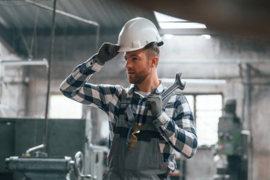 Beyaz kasketli. Üniformalı fabrika çalışanı içeride..