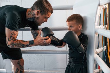 Yüzükte birlikte. Koç çocuklara kapalı alanda boks teknikleri öğretiyor..