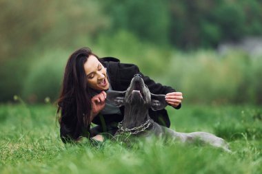 Neşeli bir ruh hali. Kulaklarından tutarak. Genç esmer kız köpeğiyle dışarıda yürüyüş yapıyor..