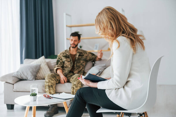 Talking to doctor. Soldier have therapy session with psychologist indoors.