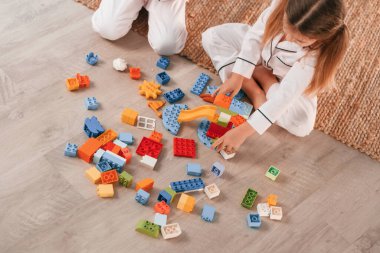 Plastik inşaat oyuncaklarıyla oynamak. İki küçük kız yurt odasında birlikte eğleniyorlar..