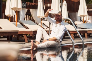 Oturuyorum, dinleniyorum. Resmi giyinmiş yakışıklı adam havuzda..