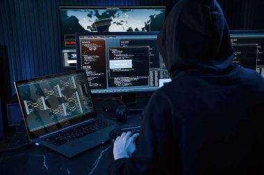 Karanlık oda. Genç profesyonel bilgisayar korsanı bilgisayar başında ve ekranlar hakkında çok fazla bilgiye sahip..