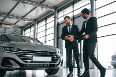 İş ortakları. Adam galeride müşteriye danışıyor..