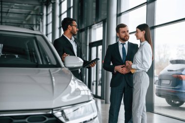 Adam galeride genç çifte danışıyor..