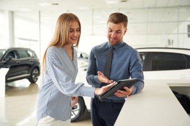 Not defterindeki bilgiler. Resmi elbiseli adam elektrikli arabalı kadın müşteriyle birlikte..