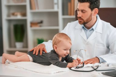 Steteskopla. Küçük bebekli doktor dolapta çalışıyor..