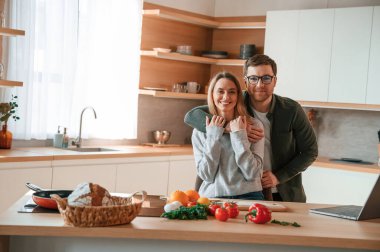 Birbirinize sarılın. Genç çift mutfakta birlikte..