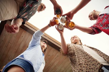 Aşağıdan bak. Bir grup insan ellerinde birayla iyi vakit geçiriyor..