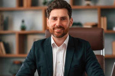 İş adamının resmi giysiler içindeki portresi kapalı alanda çalışıyor..