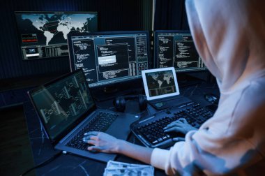 Phishing saldırısı. Genç profesyonel bilgisayar korsanı bilgisayar başında ve ekranlar hakkında çok fazla bilgiye sahip..