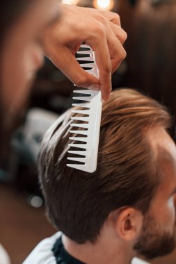 Dikiz aynası. Adam modern berber dükkanını ziyaret ediyor. Modern biçim.