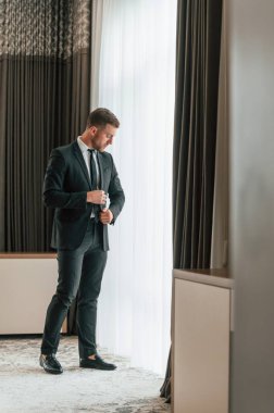 Zarafet kavramı. Takım elbiseli ve kravatlı. İş adamı içeride, otel odasında..