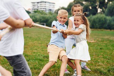 Savaş oyunu römorkörü oynuyoruz. Çocuklar gündüz vakti sahada eğleniyorlar..