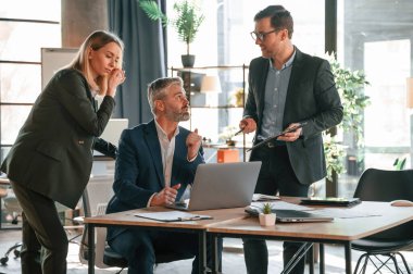 Erkek ve kadın içeride. Bir grup iş adamı modern ofiste çalışıyor..