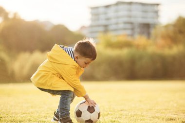 Oğlan futbol topuyla yaz sahasında..