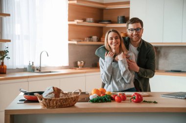 Birbirinize sarılın. Genç çift mutfakta birlikte..