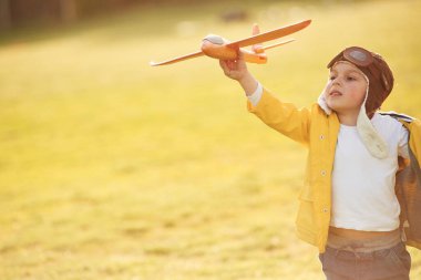 Retro stil havacı gözlükleri. Küçük çocuk yaz sahasında oyuncak uçakla oynuyor..
