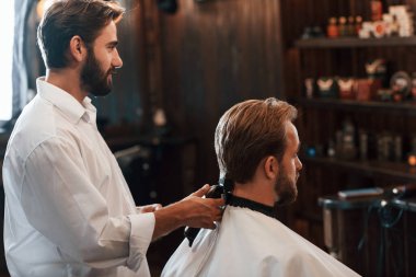 Dikiz aynası. Adam modern berber dükkanını ziyaret ediyor. Modern biçim.