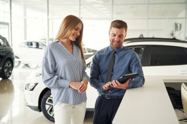 Not defterindeki bilgiler. Resmi elbiseli adam elektrikli arabalı kadın müşteriyle birlikte..