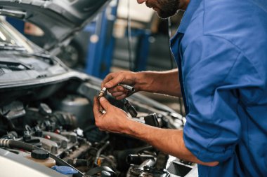 Motor tamiri. Otomobil tamircisi garajda çalışıyor. Onarım servisi.