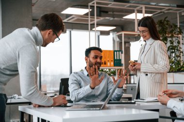 Erkekler ve kadınlar ofiste birlikte çalışıyorlar..