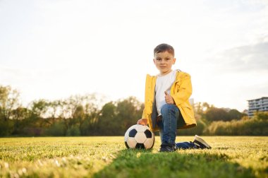 Yere yatın! Oğlan futbol topuyla yaz sahasında..