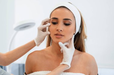 Kadın yüzü güzellik salonunda güzellik uzmanından yüz bakımı alıyor.