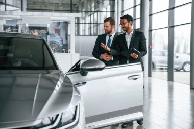 İş ortakları. Adam galeride müşteriye danışıyor..