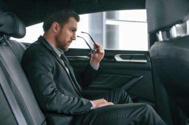 Rahat modern bir otomobilde. Resmi iş elbiseli adam..