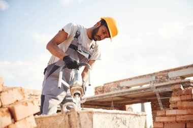 Betonu karıştırıyor. Yakışıklı Hintli adam şantiyede..
