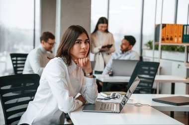 Göz kamaştırıcı kadın iş arkadaşlarının önünde. Ofiste birlikte çalışan dört kişi var..