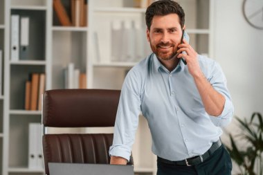 Telefonla. Resmi kıyafetli doktor dolapta çalışıyor..