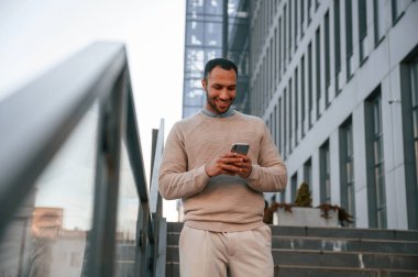 Yakışıklı siyah adam iş binasının yakınında dışarıda..