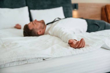 Yorgunum, yatağa uzanıyorum. İş adamı içeride, otel odasında..